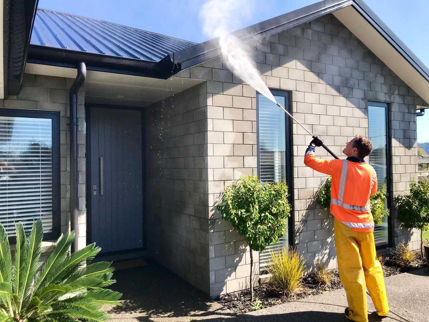 house washing specialist cleaning a house exterior