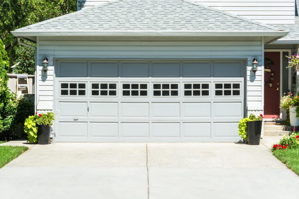 The garage door of a home with a concrete driveway.