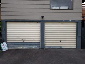 Two scuffed up garage doors needing repairs.