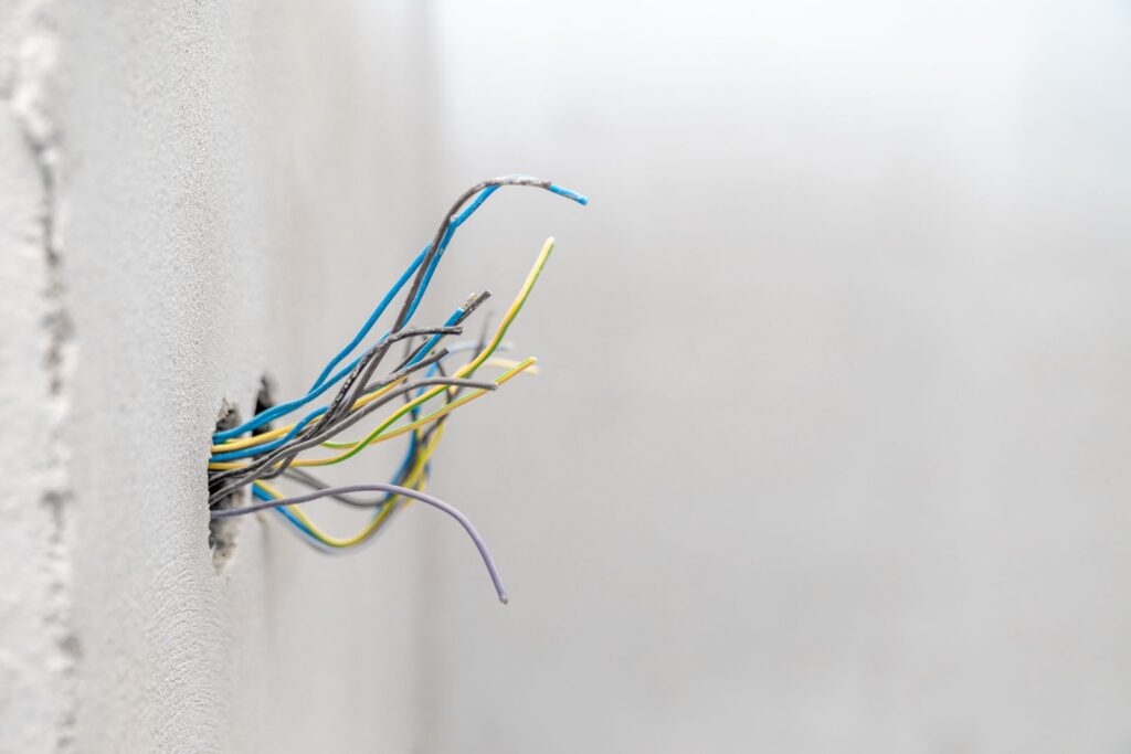 electrical wires sticking out of hole in wall