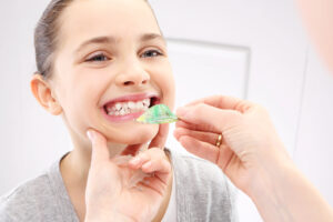 A child with malocclusion in the process of getting an orthodontic appliance fitted to her teeth.