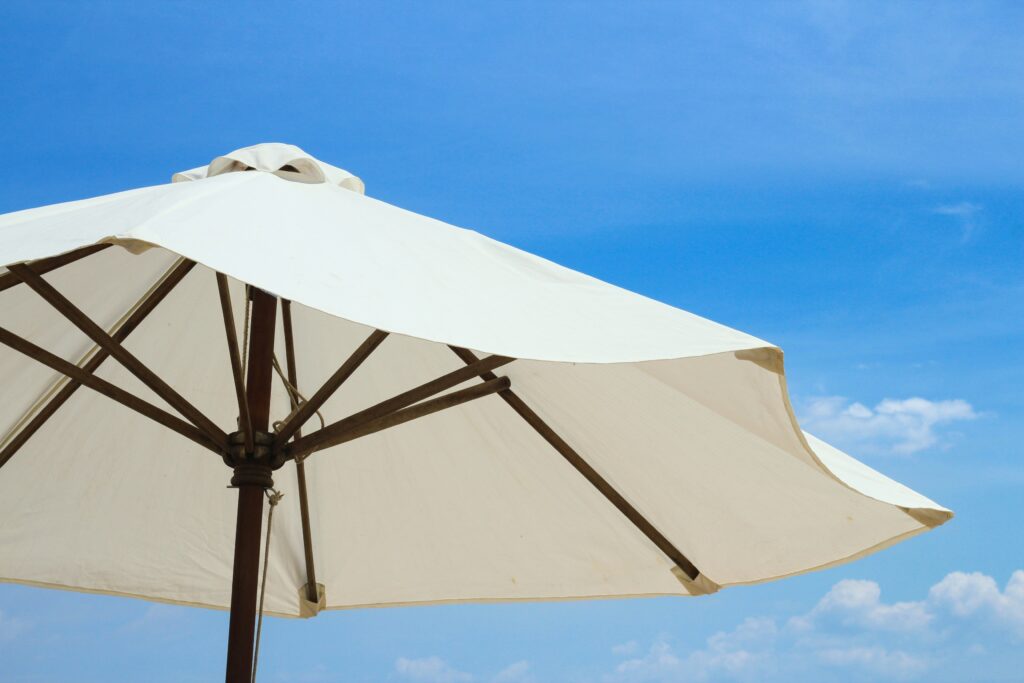 A white umbrella with a blue sky in the background