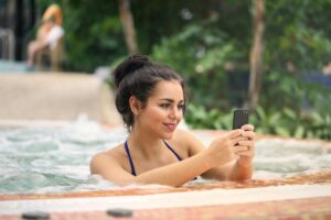 woman in spa pool using smartphone